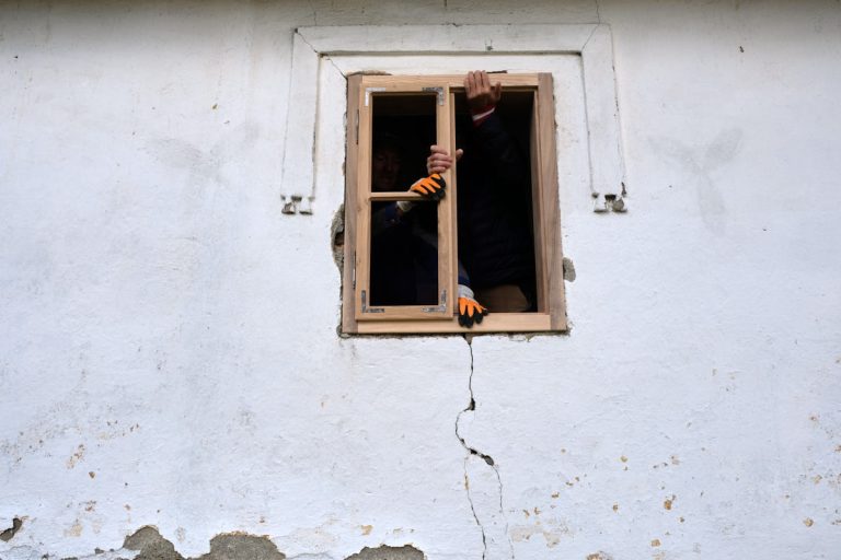 a new wooden window and workers hands during the installation process