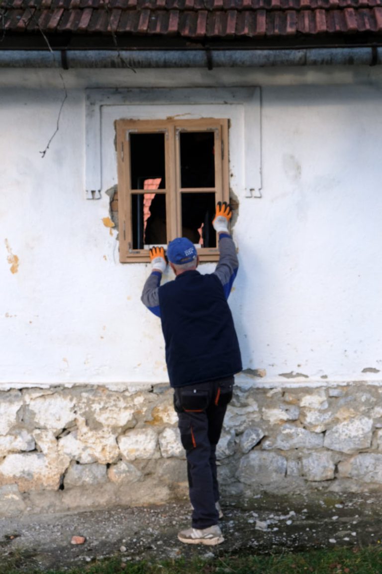 a worker holding a window during the installation