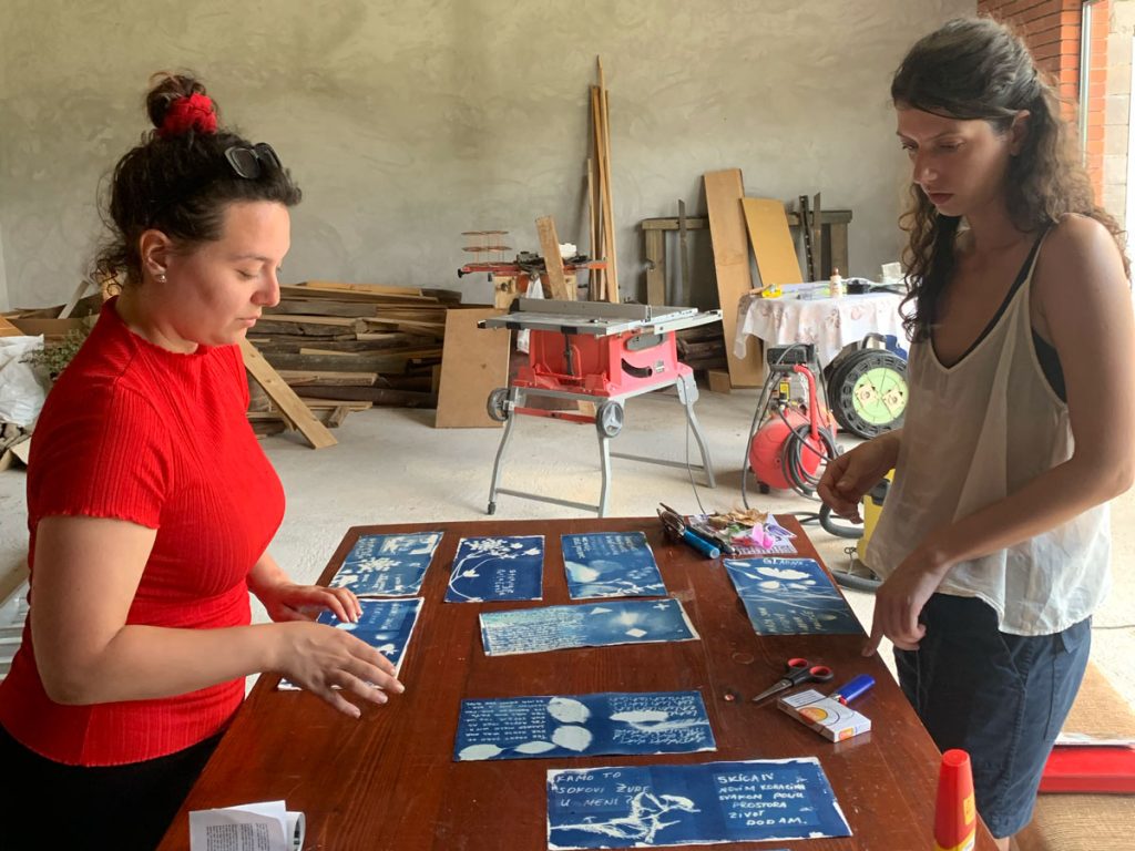 women viewing a cyanotype book