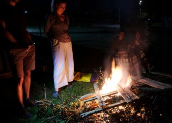 people gathering around a bonfire in the backyard