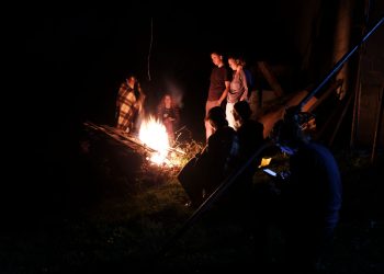 people gathering around a bonfire in the backyard